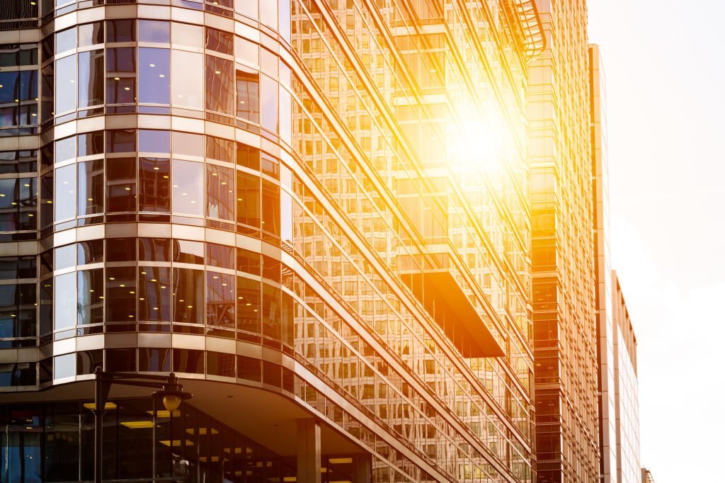 Cityscape featuring modern office exterior from a low angle at sunset.